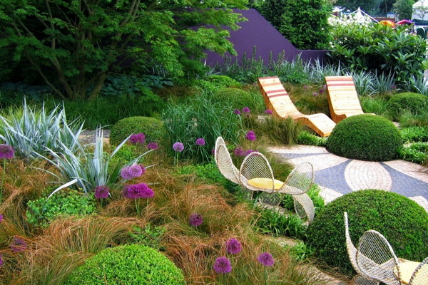 Подивіться на фото зони відпочинку в саду: поруч з нею чудово виглядають квітники, клумби, декоративні чагарники: